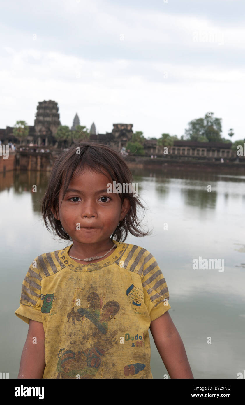 Young poor girl aged 4 in front of river at famous Angkor Wat in Siem ...