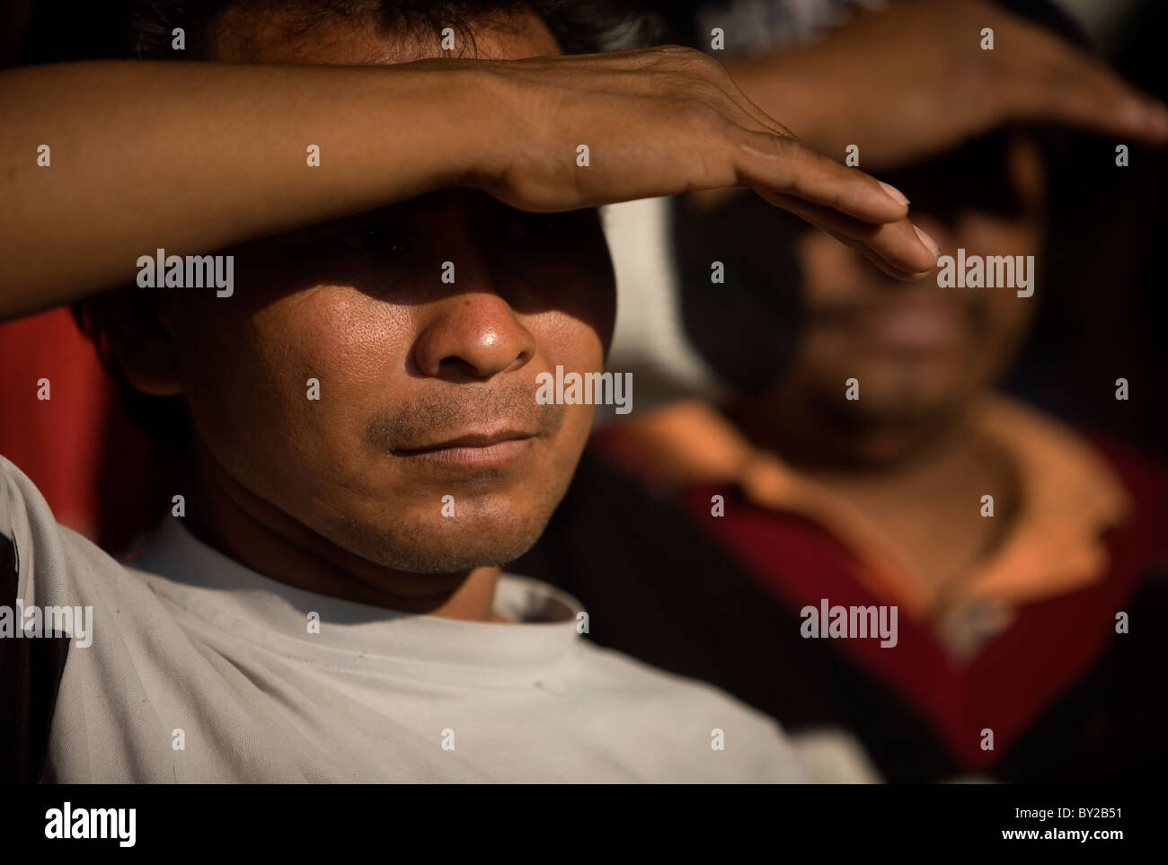 Central American migrants cover their eyes with his hands in a shelter located along the railroad in Ixtepec, Oaxaca, Mexico. Stock Photo