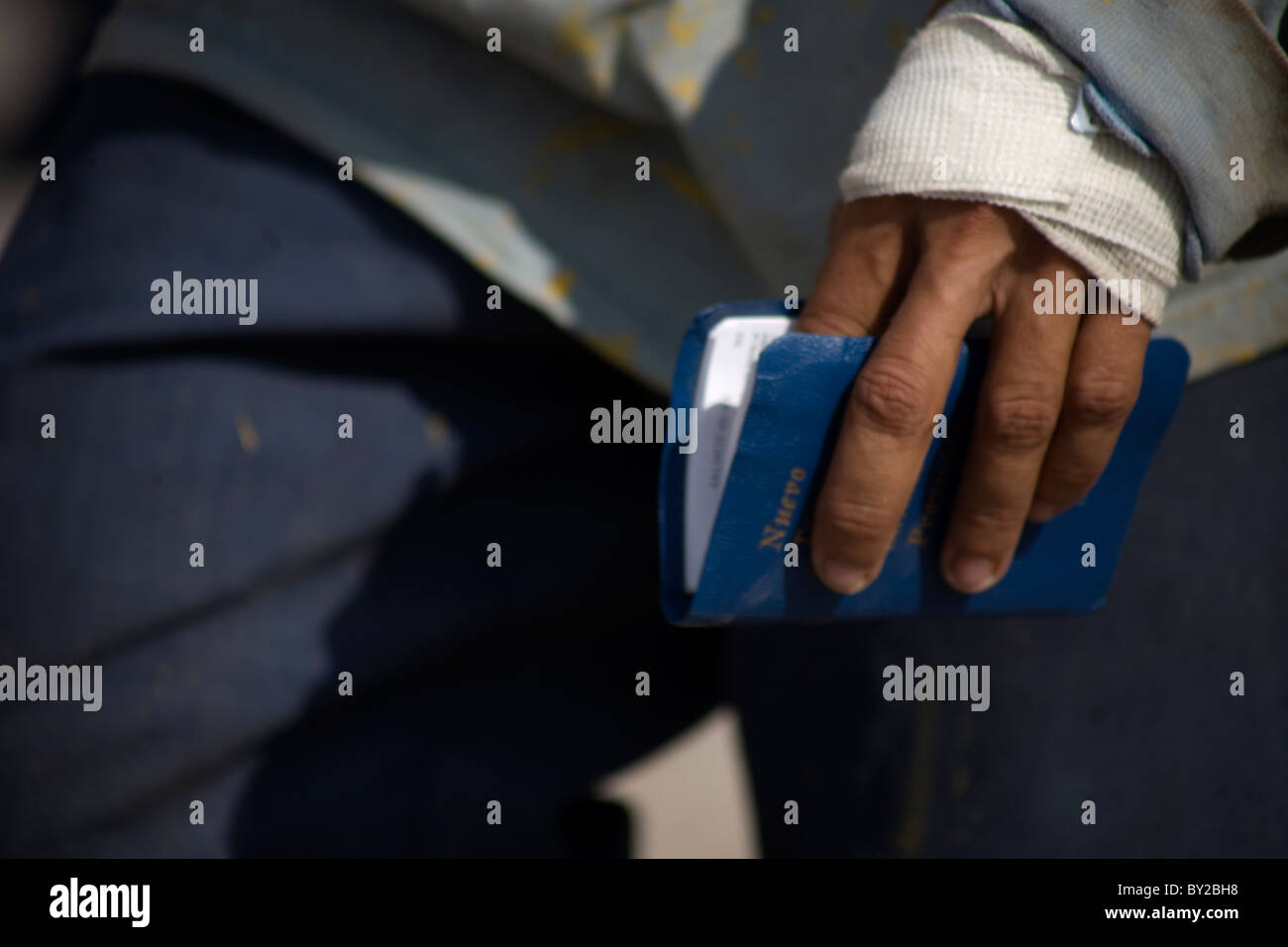 A Central American migrant holds a Bible in a shelter located along the railroad in Ixtepec, Oaxaca, Mexico. Stock Photo