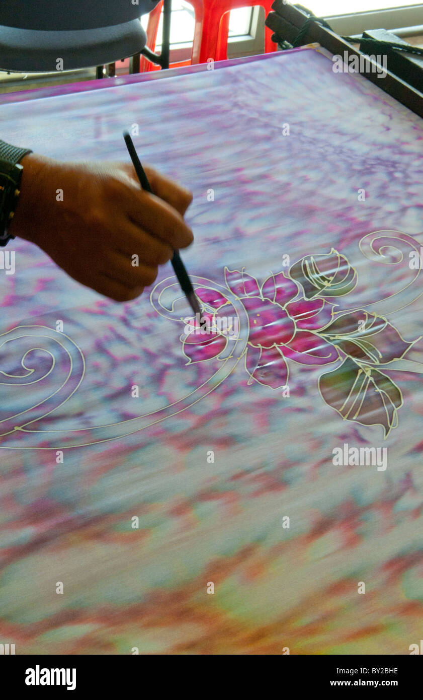 Artist painting Batik Design paint artwork on silk factory in Kuala