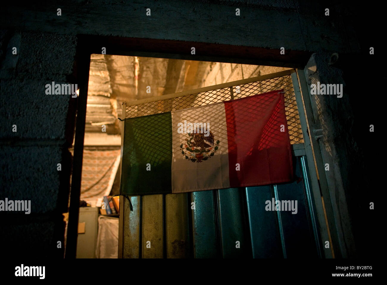 A Mexican flag decorates a door of a shelter located along the railroad in Ixtepec, Oaxaca, Mexico. Stock Photo