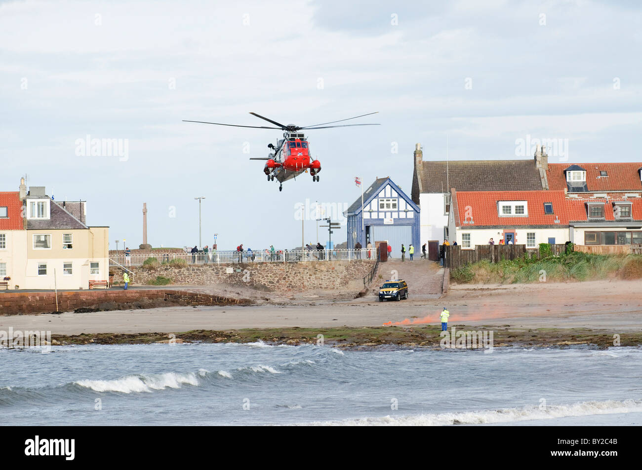 Search and rescue helicopter landing on a beach in North Berwick, Scotland. The site is marked by flares set by the coastguard. Stock Photo