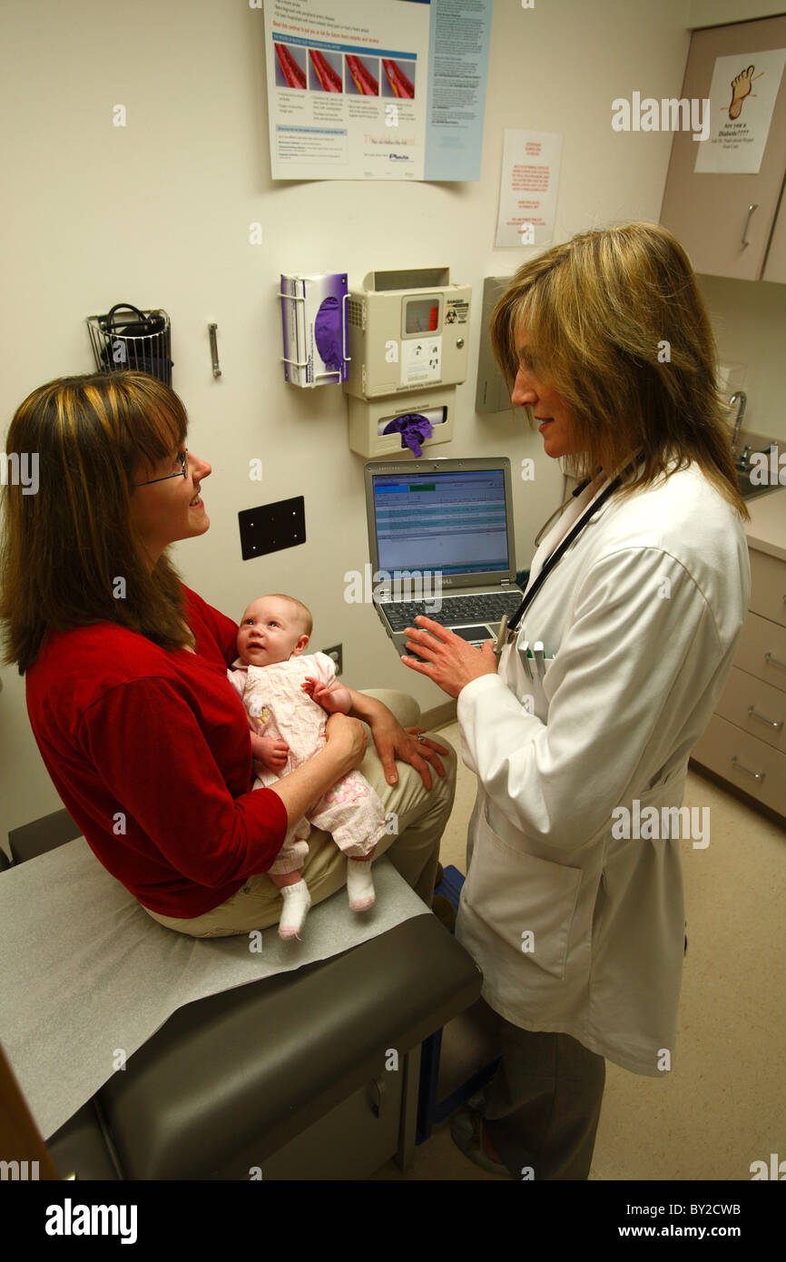 Female doctor consults with a patient while using electronic health records Stock Photo
