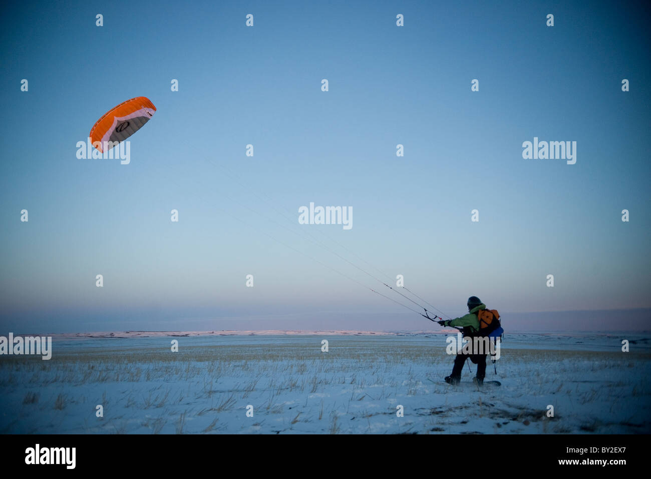 A young man taking off with his snowkite. Stock Photo