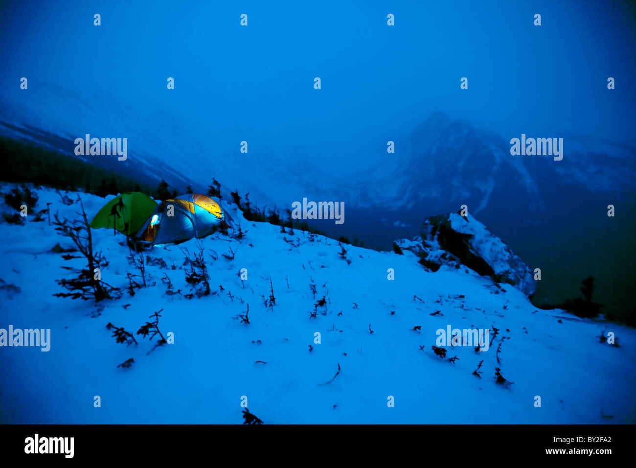 Two tents sit in the snow, side by side, as night falls on Mt. Washnigton. Stock Photo