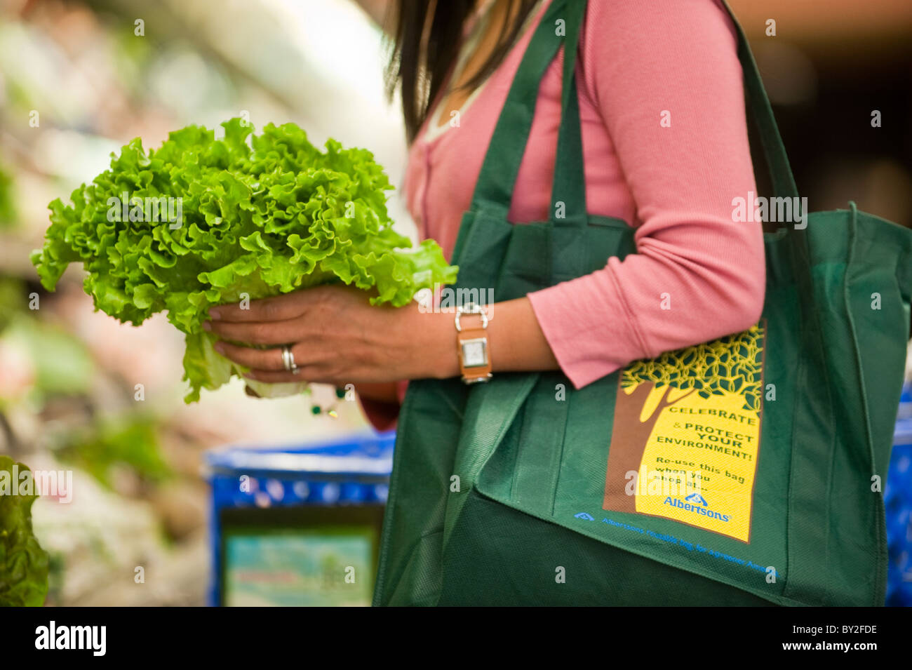 A woman using recyclable shopping bags while shopping in a supermarket