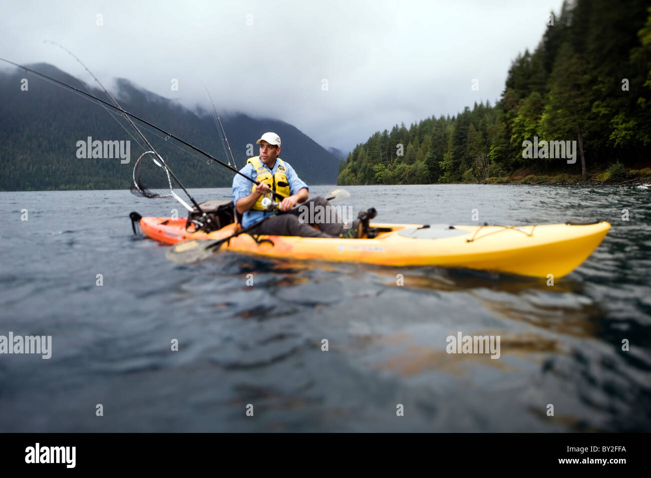 Young male fishing from a kayak on Lake Crescent Olympic National Park