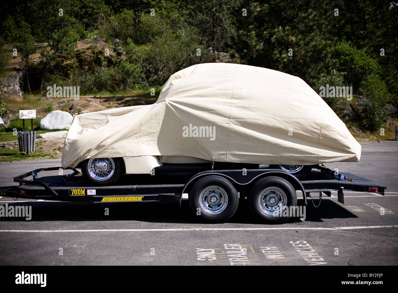 A classic car covered in a sheet on a trailer near Tubbs Hill in Coeur D'Alene, Idaho. Stock Photo