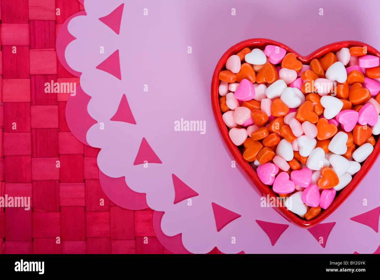 Heart shaped sweets in a heart shaped dish for Valentine's Day Stock Photo