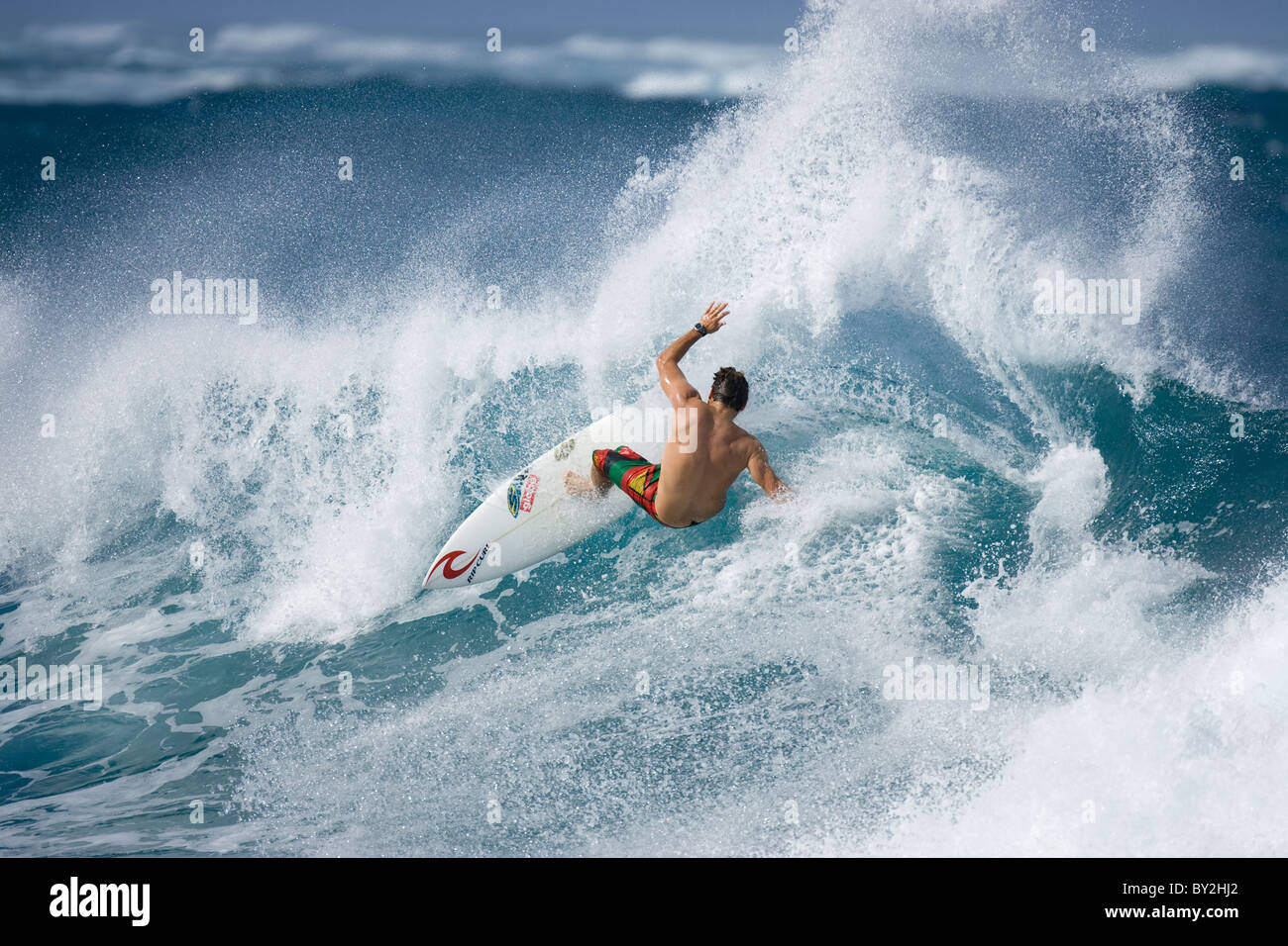 A young man surfing at Turtle Bay, on the north shore of Oahu, Hawaii