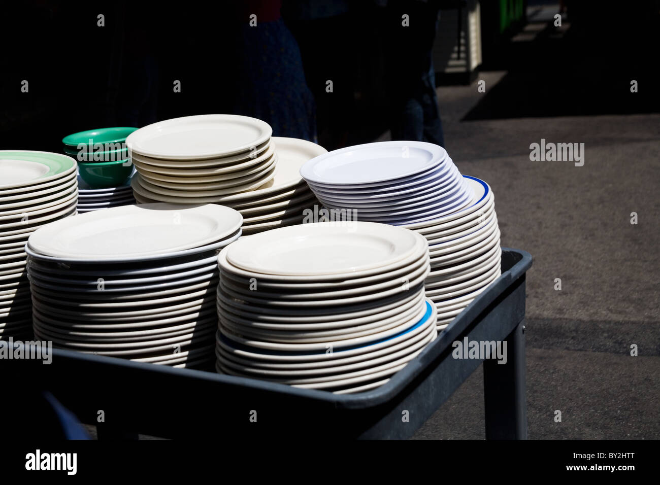 Piles of dishes on a cart at an outdoors market Stock Photo
