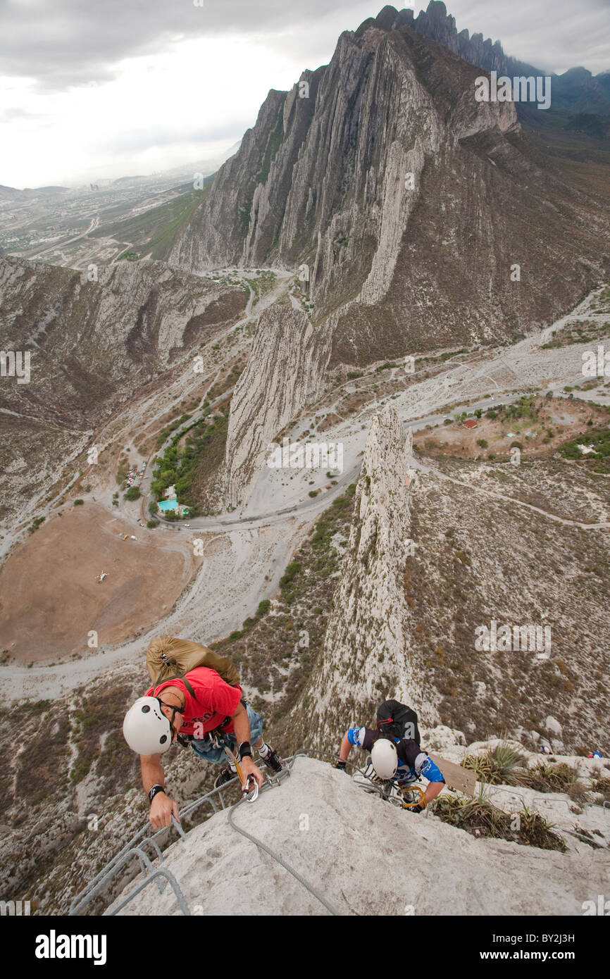 Two men climbing a via ferrata in La Huasteca, Nuevo Leon, Mexico. Stock Photo