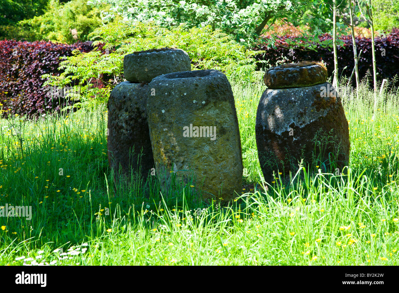 Three decorative old pots or urns in an English country garden in summer Stock Photo