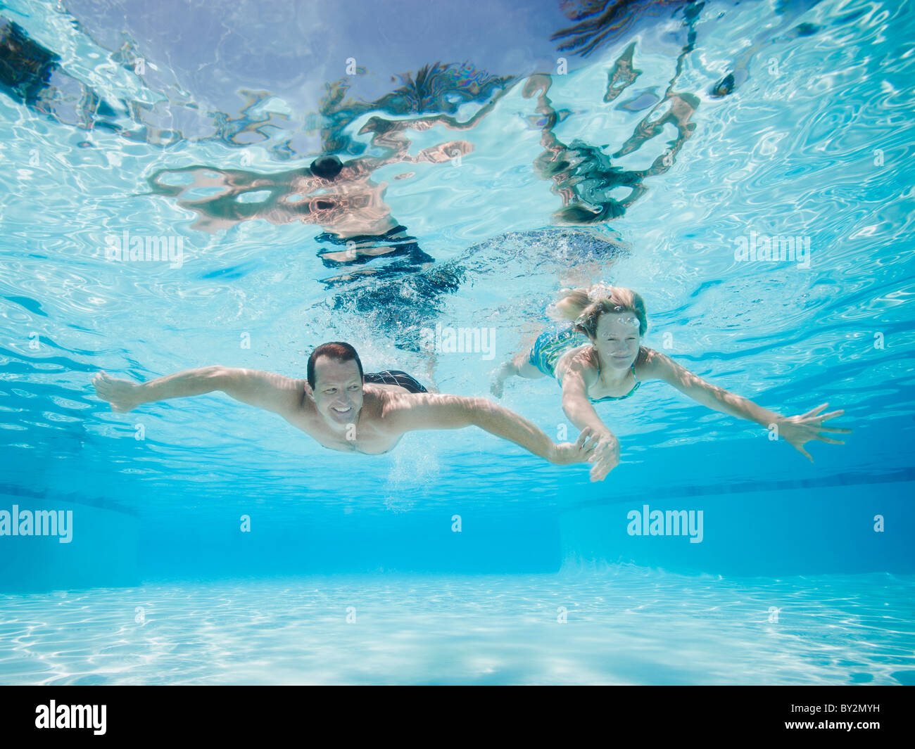 Mid adult couple swimming underwater Stock Photo - Alamy