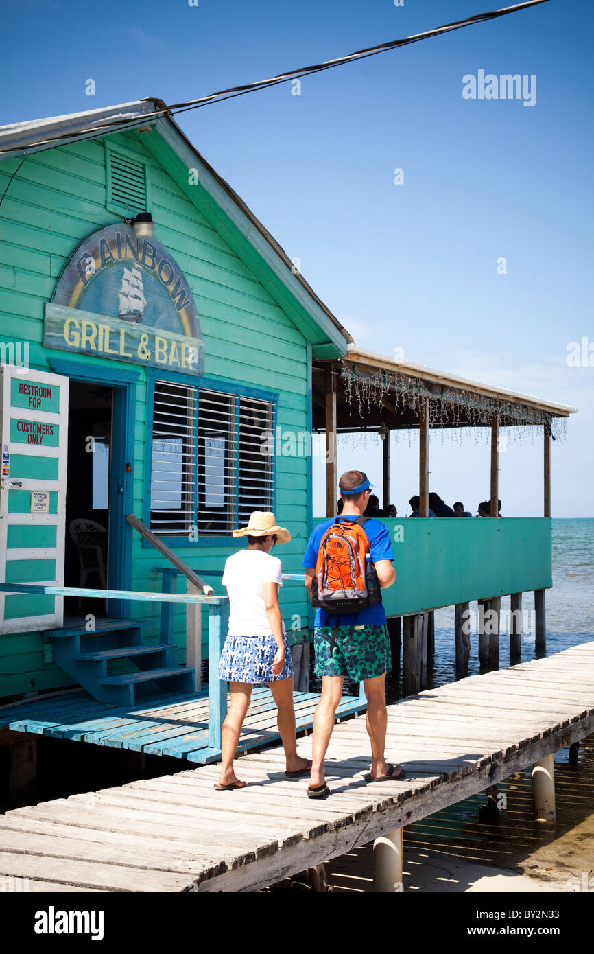 A couple walk down a dock near a ocean side restaurant. Stock Photo