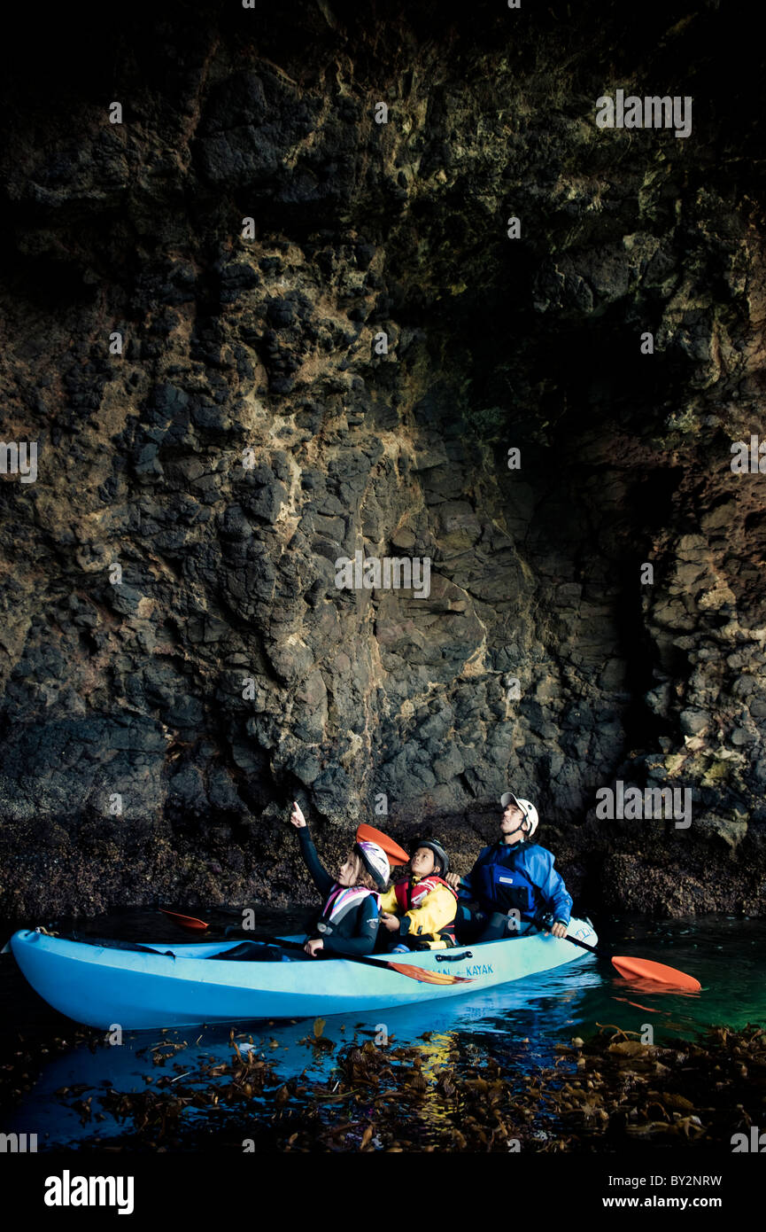 Young children explore sea caves by kayak on Santa Cruz Island in the