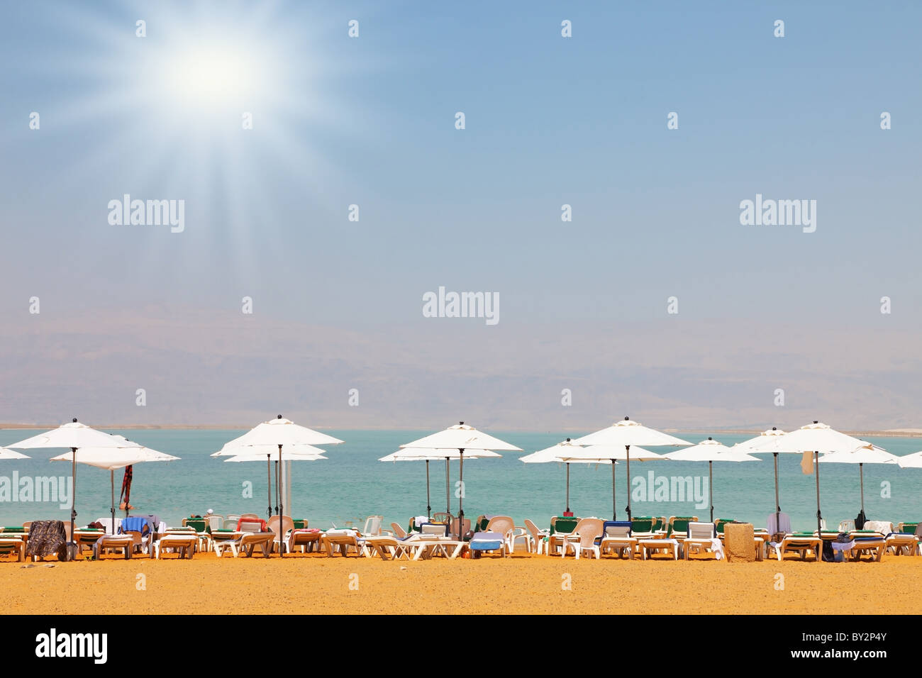 Sun beds, chairs, umbrellas and awnings on the beach luxury hotel on the Dead Sea in Israel. Sunny spring day Stock Photo