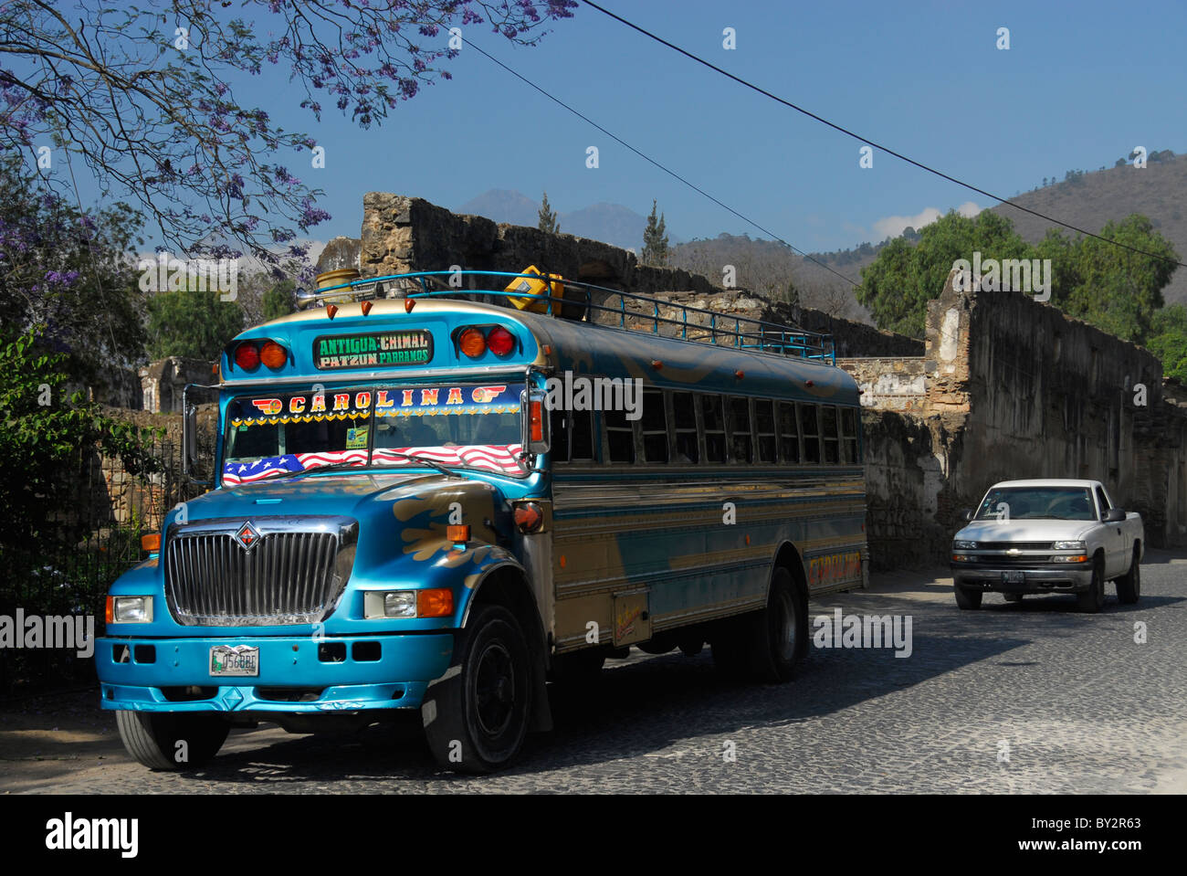 Guatemala Guatemalan Latin American Spanish Hispanic bus van autobus public transport passer by passers-by narrow street capital Stock Photo