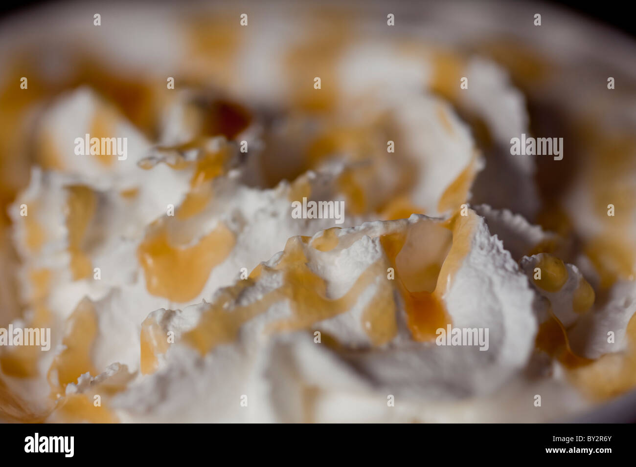 Yummy whipped cream with caramel syrup  with great texture and shallow depth of field.  Delish! Stock Photo