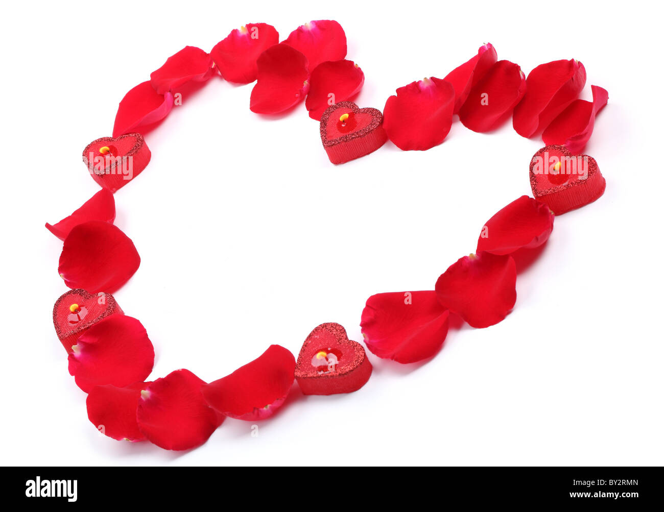 Rose petals and candles forming heart shape on white background Stock ...