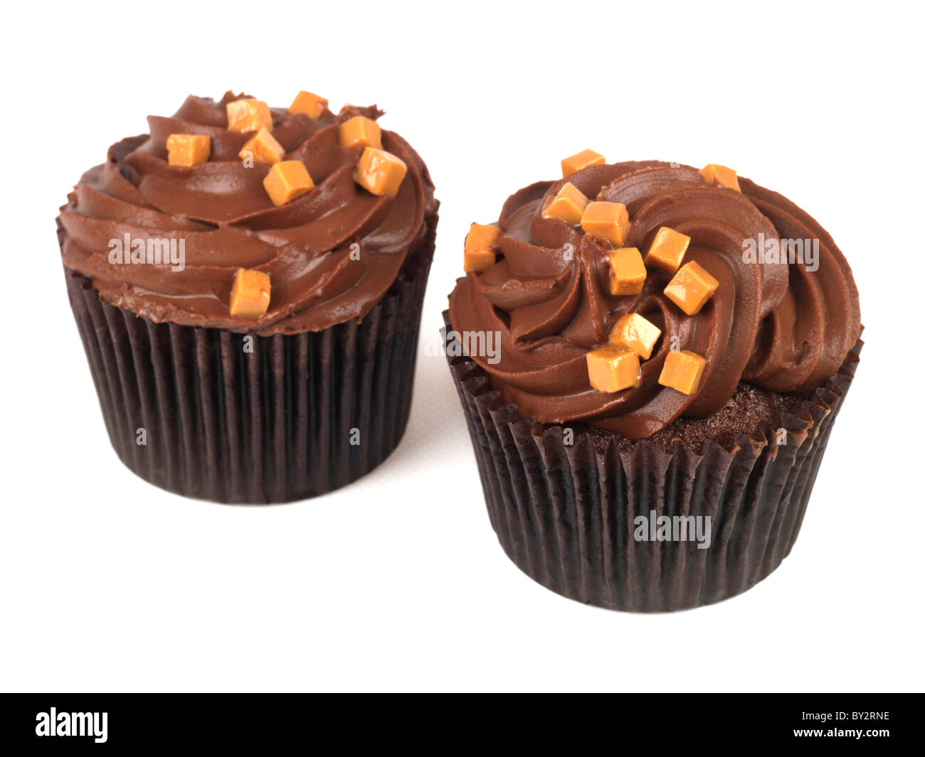 Tasty Authentic Chocolate Cup Cakes With Caramel Chunks And Fondant Icing Desserts Against A White Background With A Clipping Path And No People Stock Photo