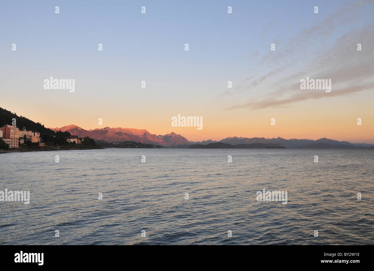 Cerro Lopez and Andean peaks glowing red in morning sunlight across waters of Lake Nahuel Huapi, Bariloche waterfront, Argentina Stock Photo