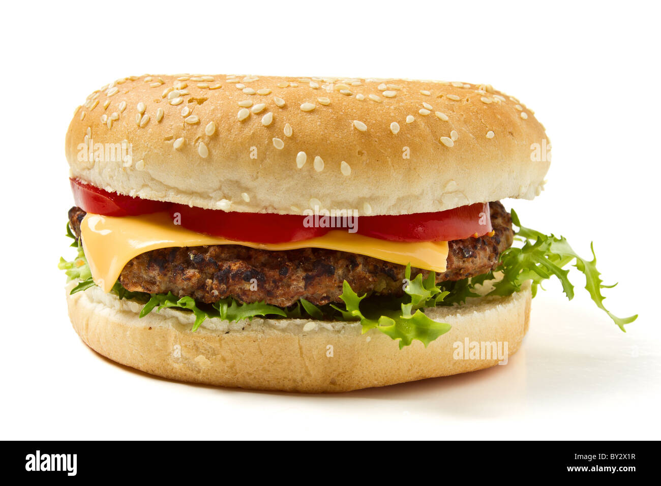 Cheeseburger in sesame seeded bun isolated on white. Stock Photo