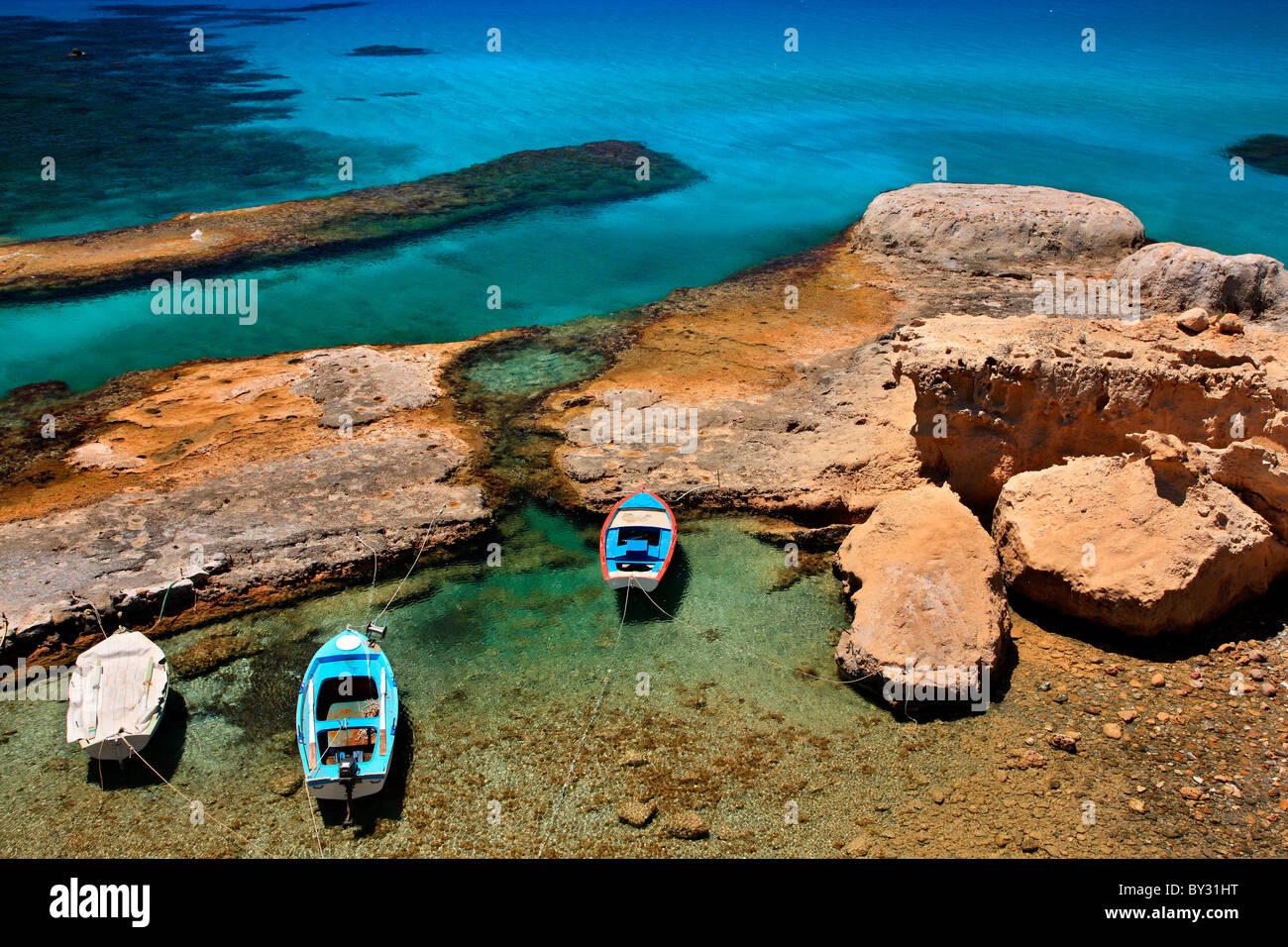 Milos island, Greece. A small natural 'harbor' very close to Fyriplaka beach with fishing boats and crystal clear waters. Stock Photo