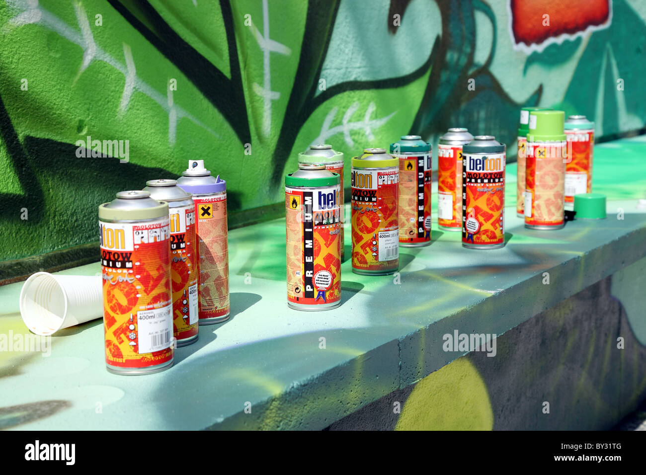 Spray cans in front of a wall Stock Photo