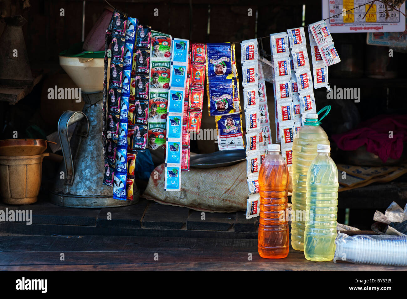 Indian petrol sold in plastic bottles with hair product sachets in a shop. Puttaparthi, Andhra Pradesh, India Stock Photo