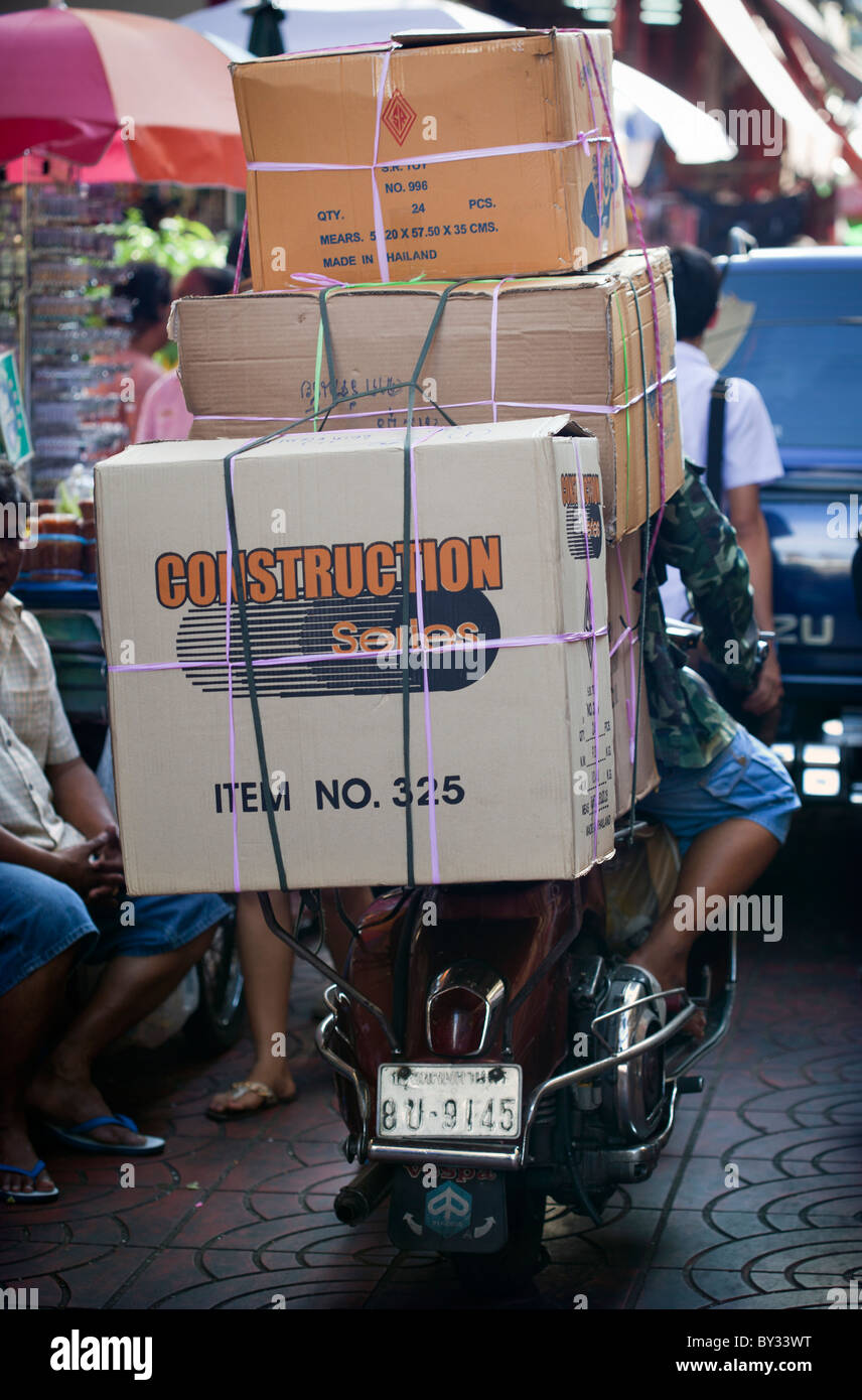 Classic Vespa Scooter making delivery amongst the crowds of Chinatow Bangkok Thailand Stock Photo