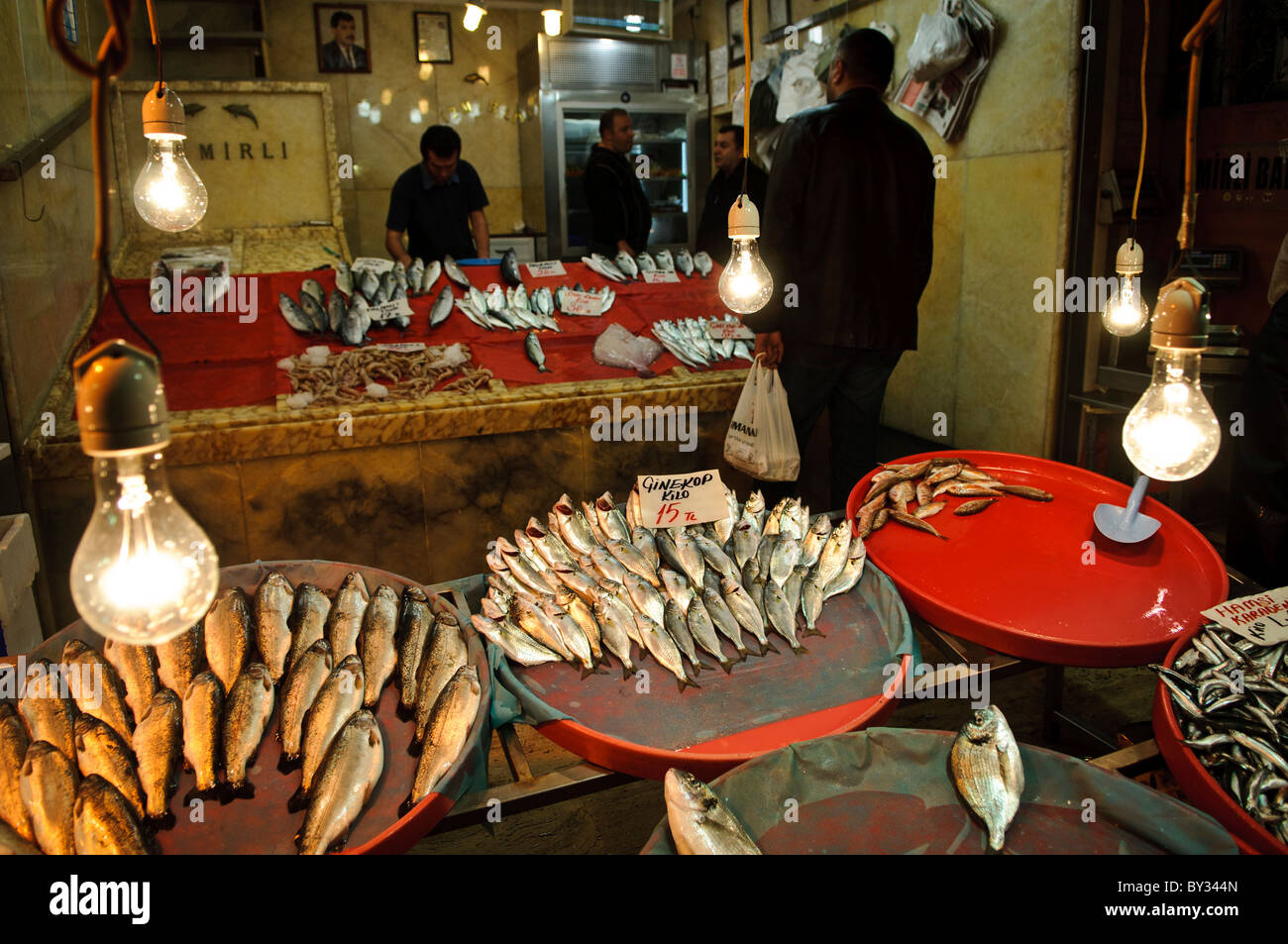 Customers buying fish at a fish shope next to the Spice Bazaar (also known as the Egyption Bazaar) in Istanbul, Turkey. Stock Photo