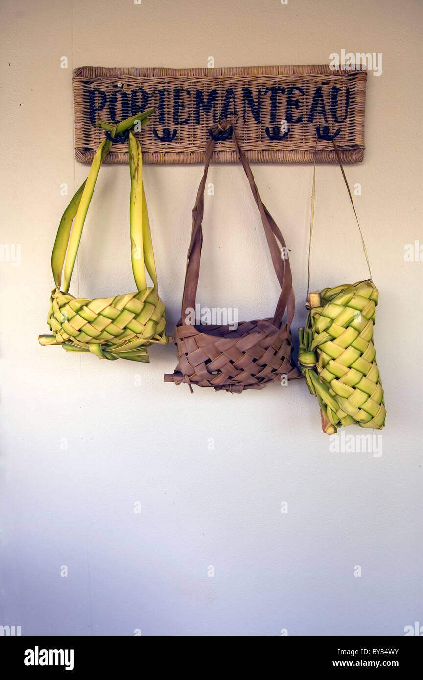 Traditional bags made from coconut palm fronds hanging on portemanteau hooks Stock Photo