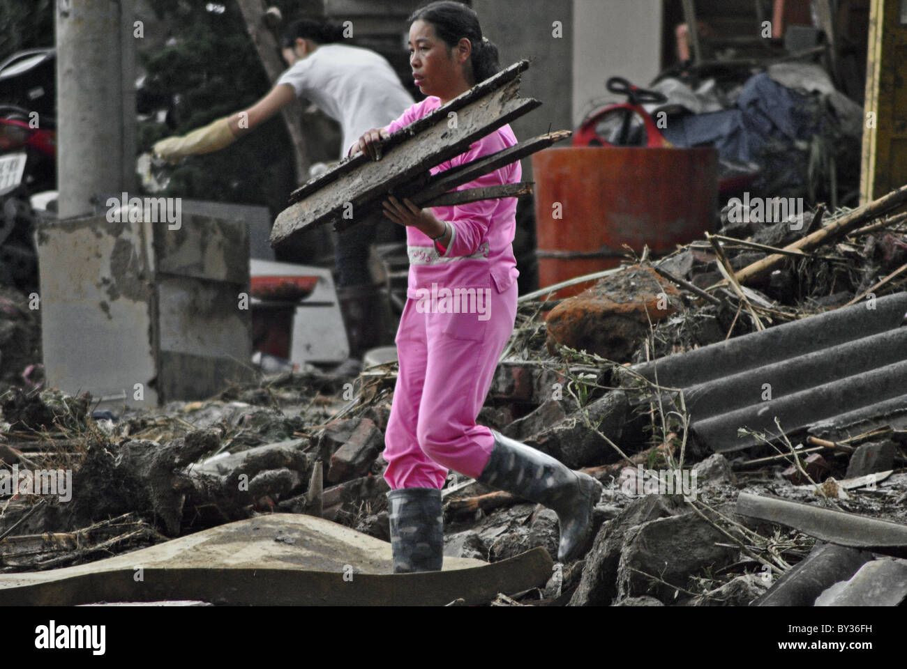 Woman clearing debris from the scene of a landslide in Sapa, Vietnam Stock Photo