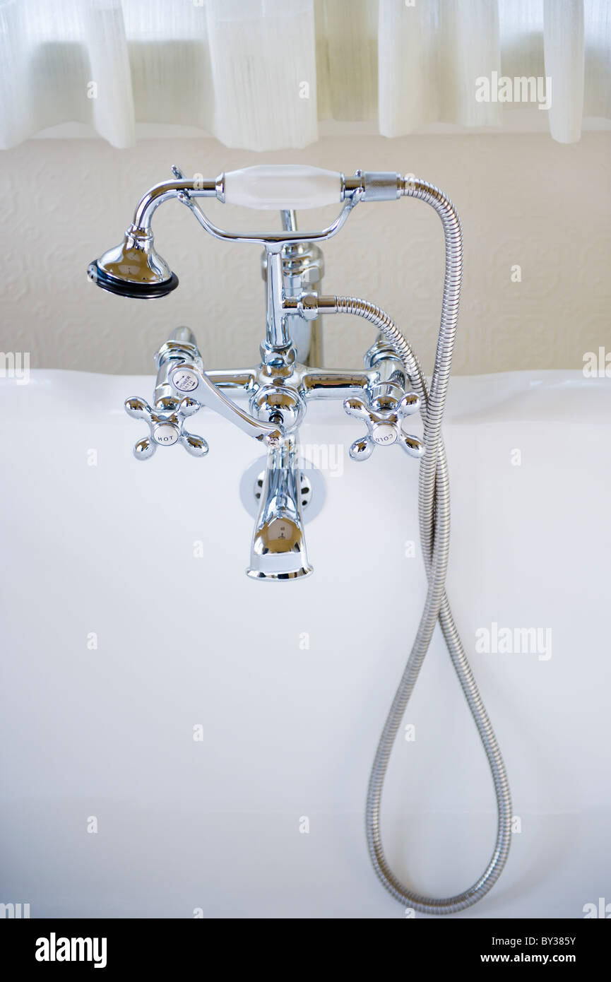 Shower head connected to tap on bath Stock Photo
