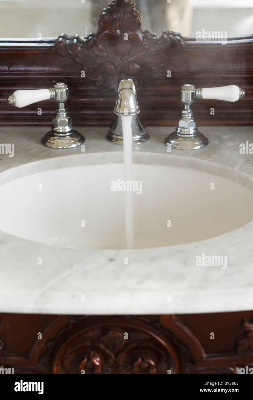 Bathroom sink with hot water running Stock Photo
