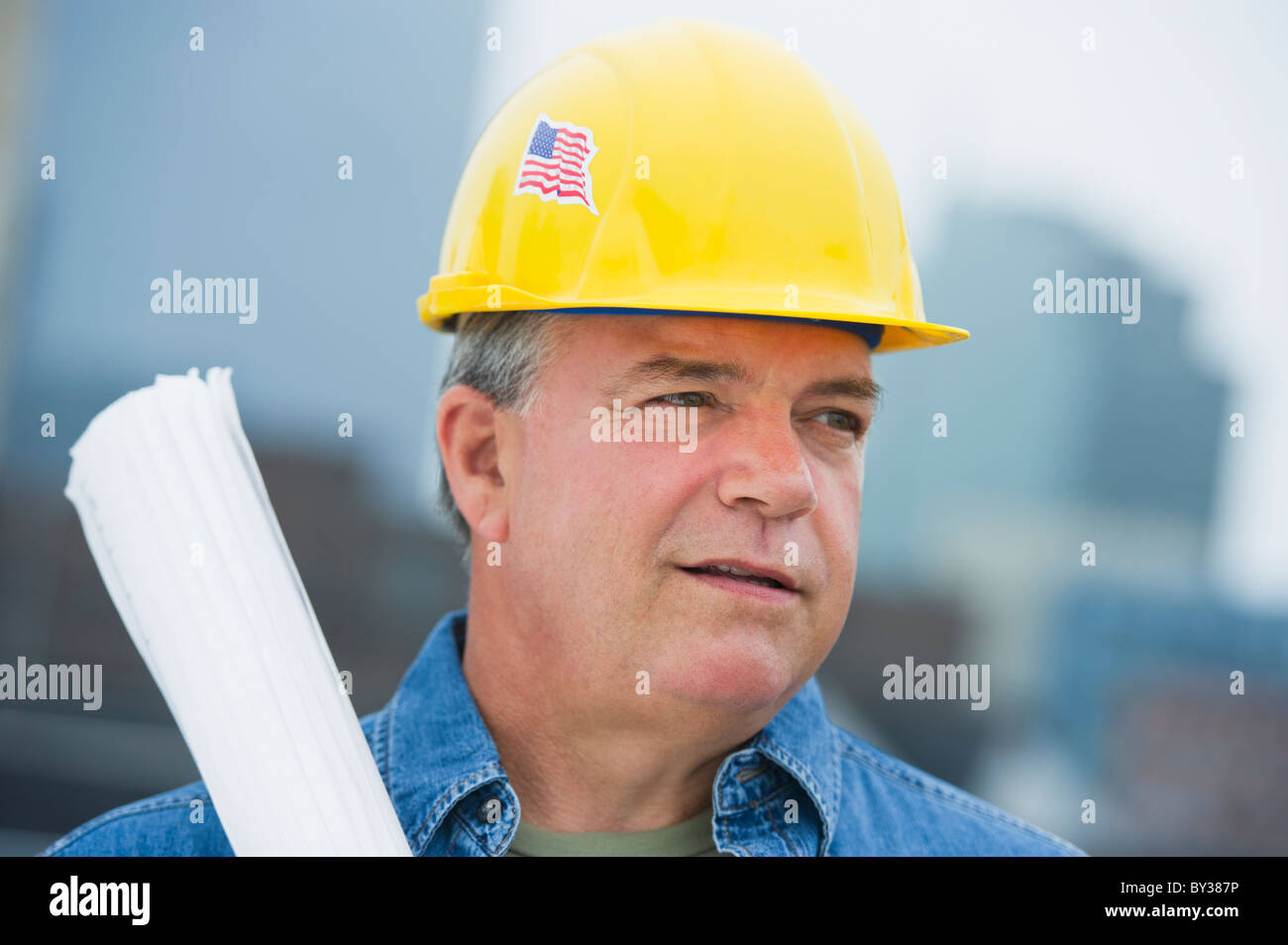 USA, New Jersey, Jersey City, Construction worker holding blueprints on