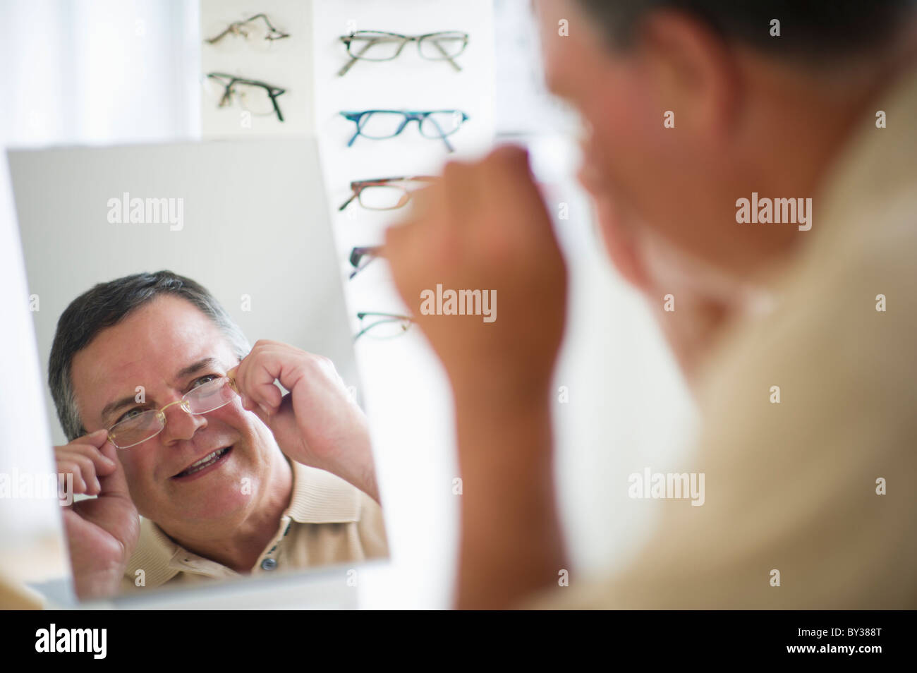 USA, New Jersey, Jersey City, Man trying on glasses in shop mirror Stock Photo