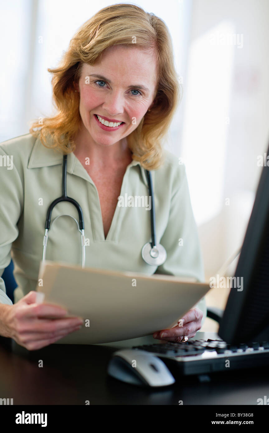 USA, New Jersey, Jersey City, Portrait of female doctor holding medical record in office Stock