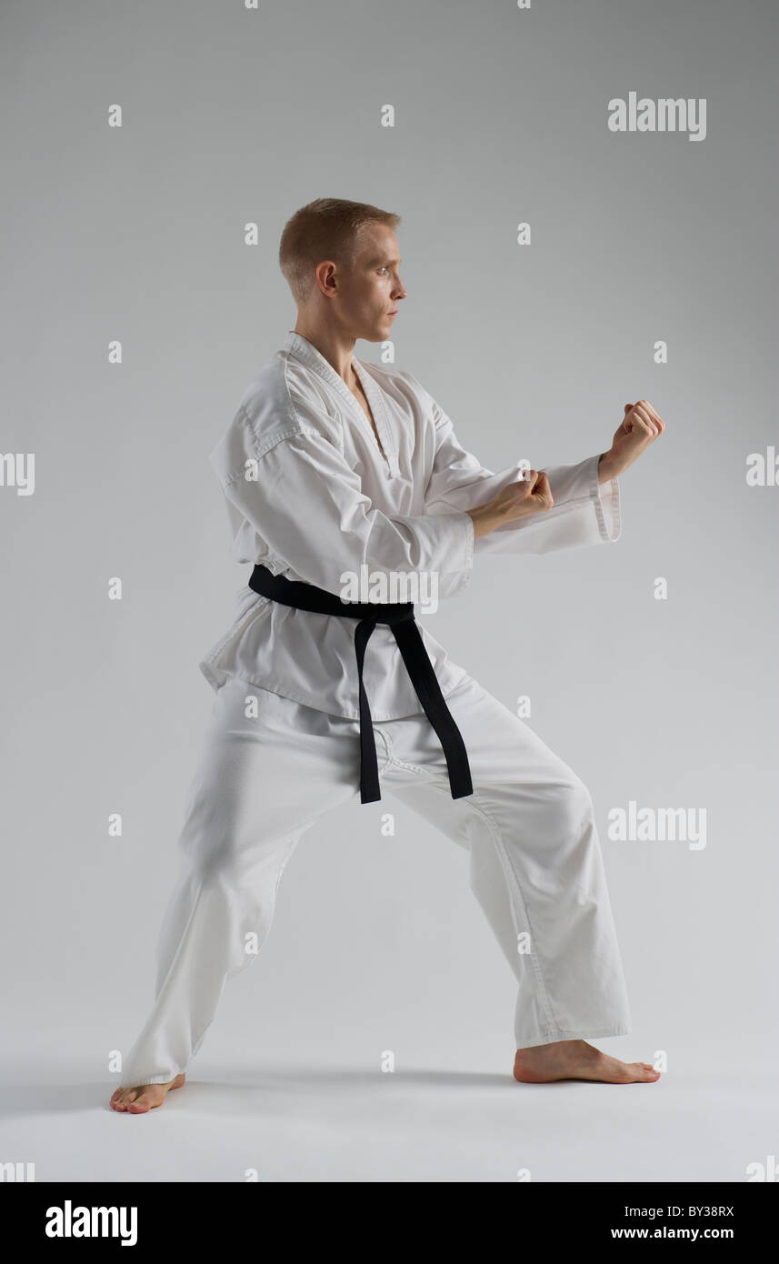 Young man performing karate stance on white background Stock Photo