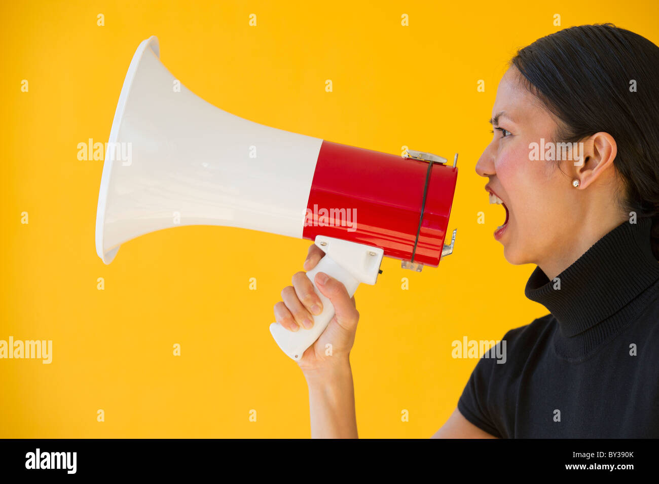 Woman shouting through megaphone Stock Photo