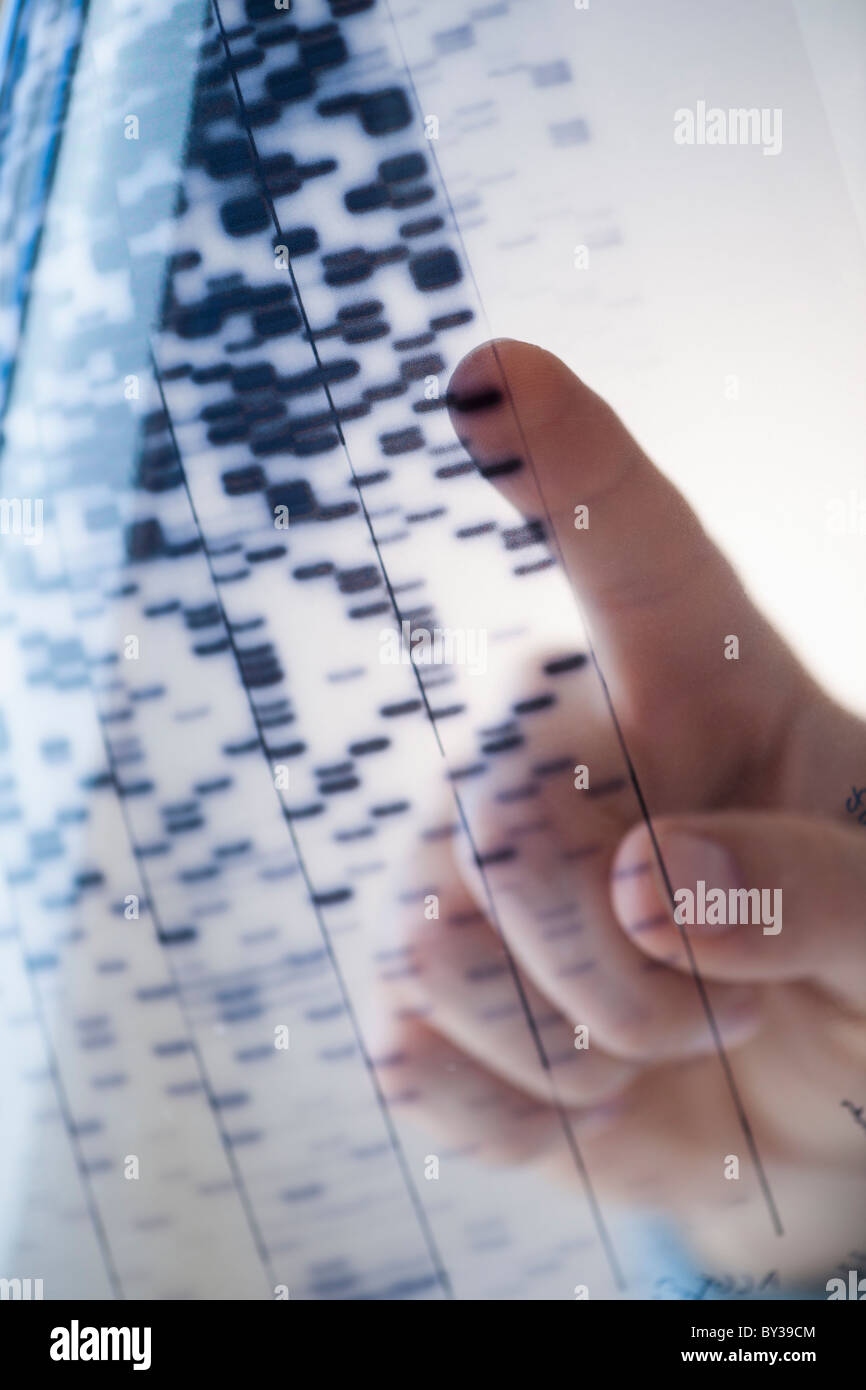 Human finger touching DNA chart Stock Photo