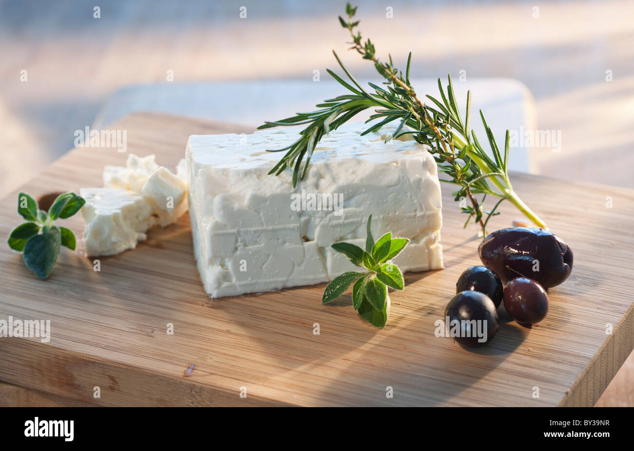 Cheese with herbs on chopping board Stock Photo