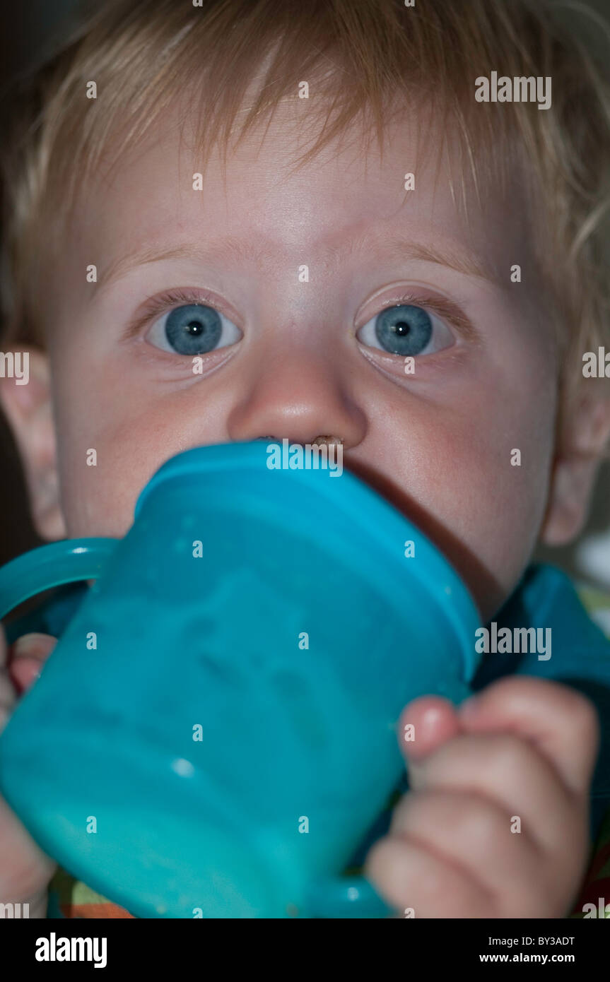 Toddler drinking milk out of a beaker Stock Photo Alamy