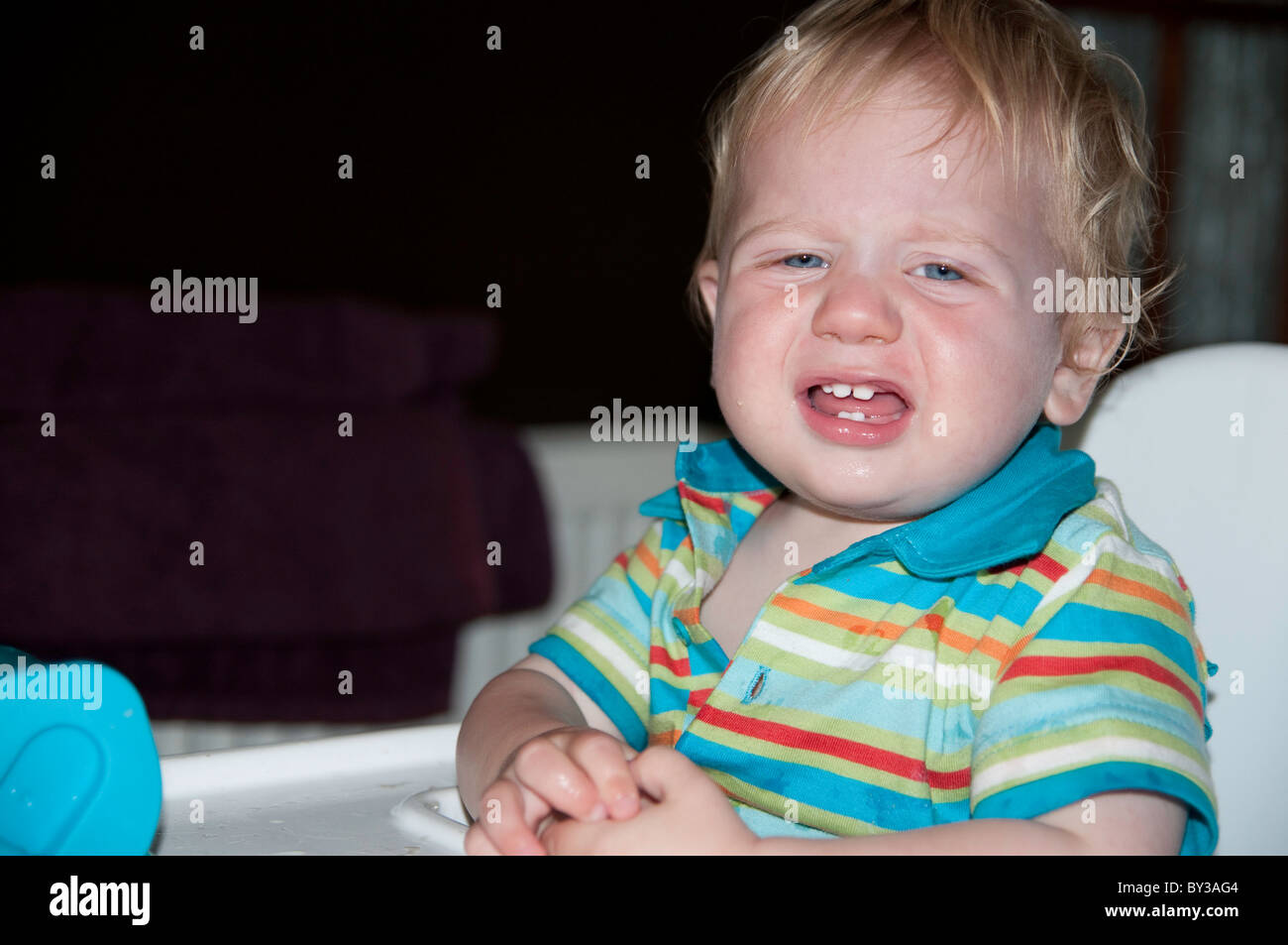 Toddler in high chair crying Stock Photo Alamy