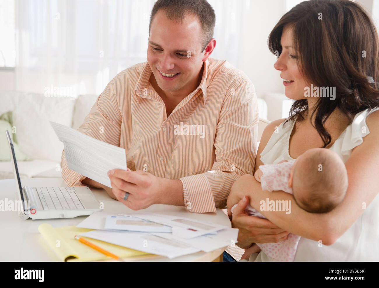 USA, New Jersey, Jersey City, Family with baby daughter (2-5 months) reading correspondence Stock Photo