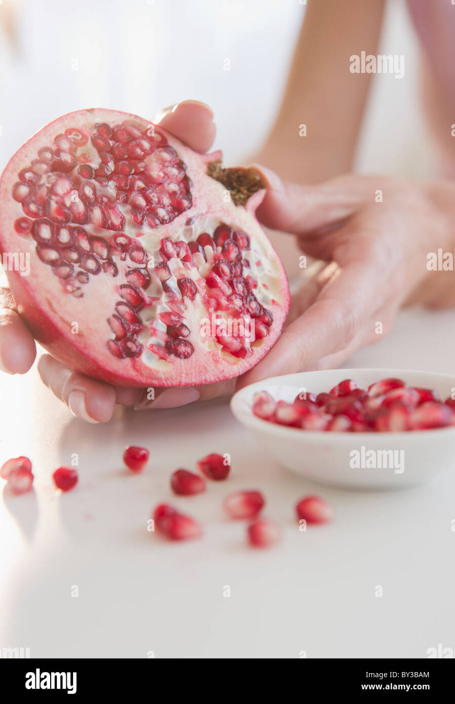 USA, New Jersey, Jersey City, Womans hand with pomegranate cross-section Stock Photo