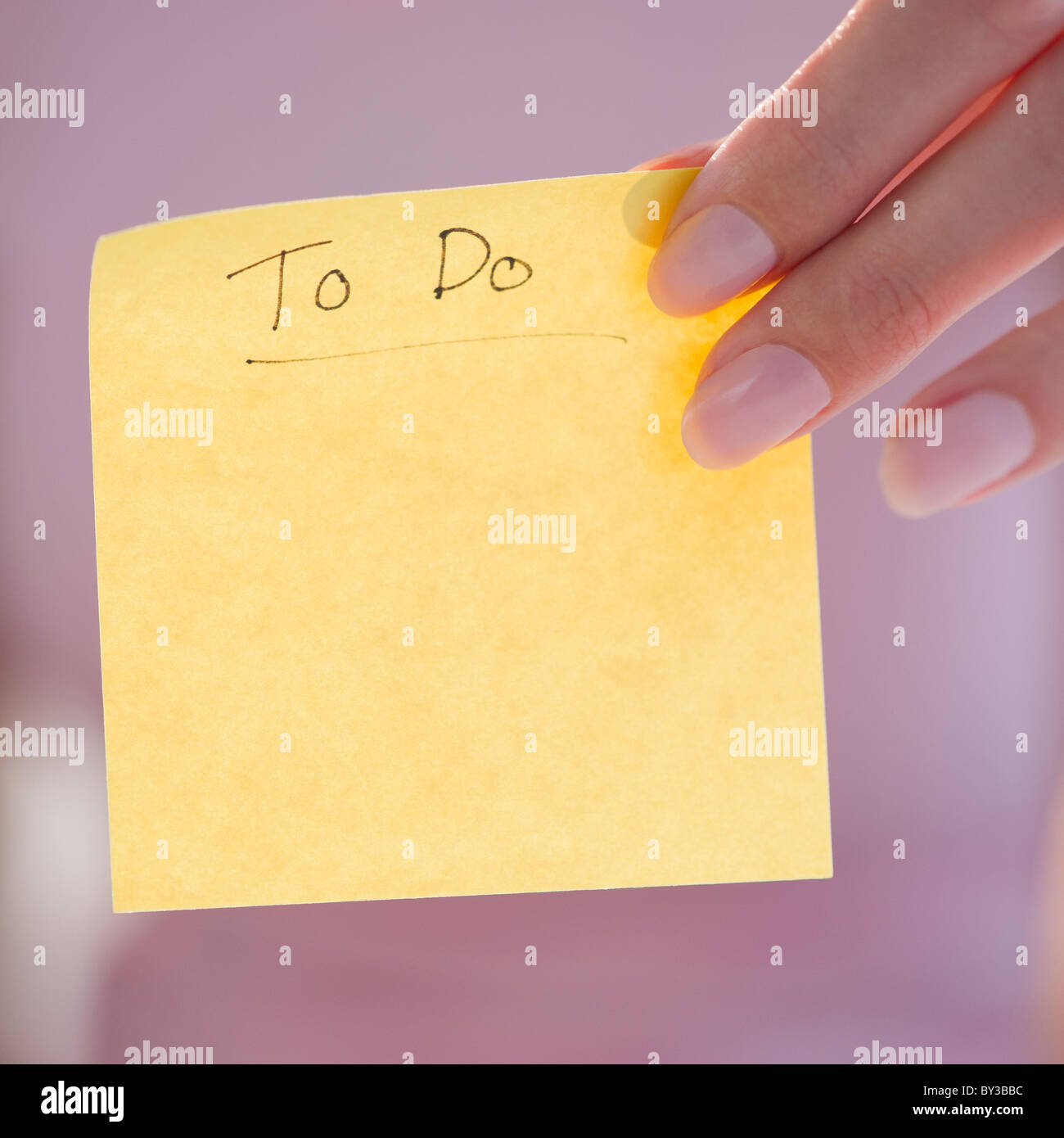 USA, New Jersey, Jersey City, Close-up view of woman hand holding adhesive note for writing down things to do Stock Photo