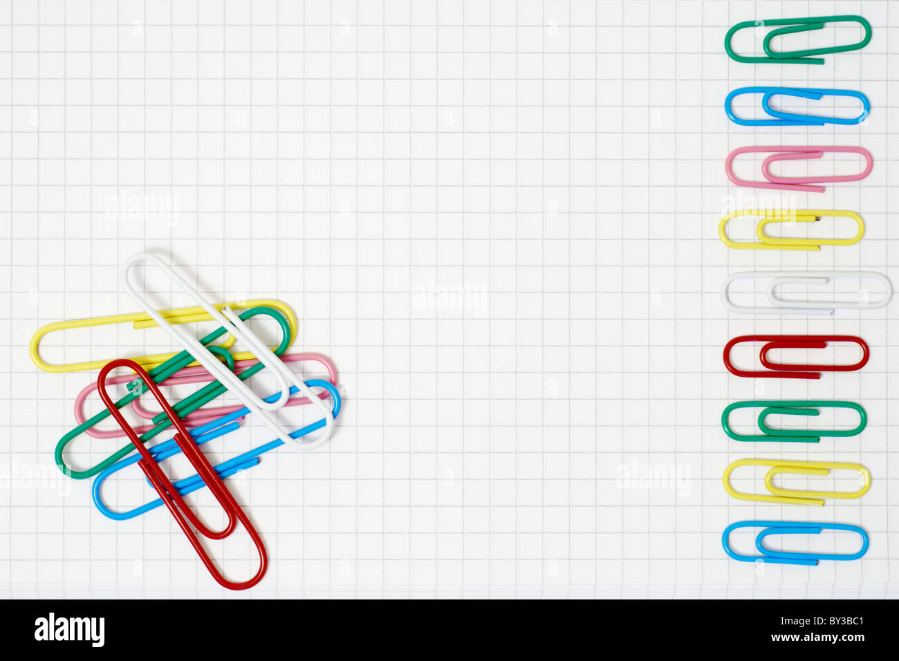 Color paper clips on the squared white paper Stock Photo