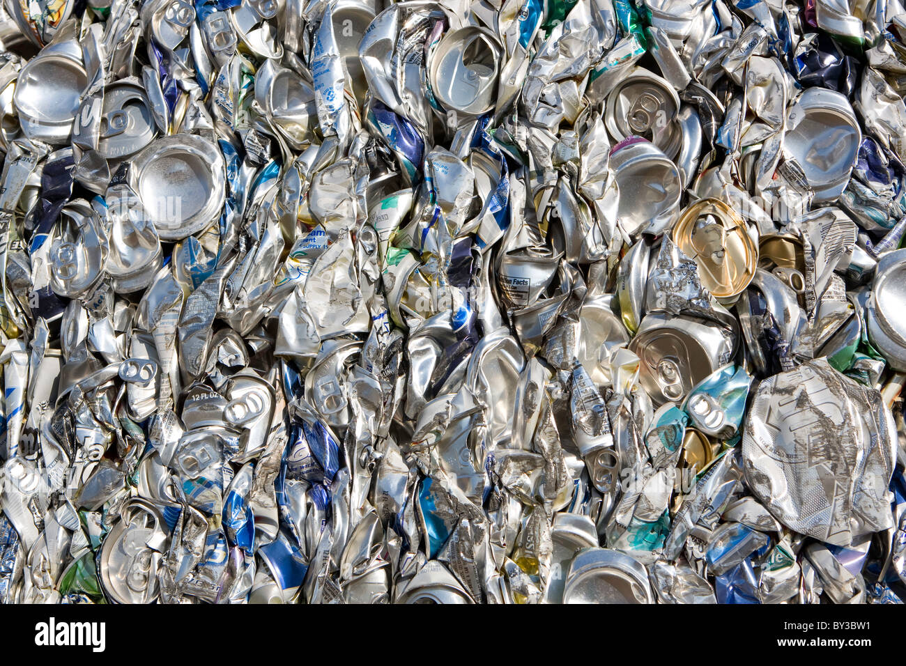Crushed aluminum cans compressed together wait to be recycled. Stock Photo
